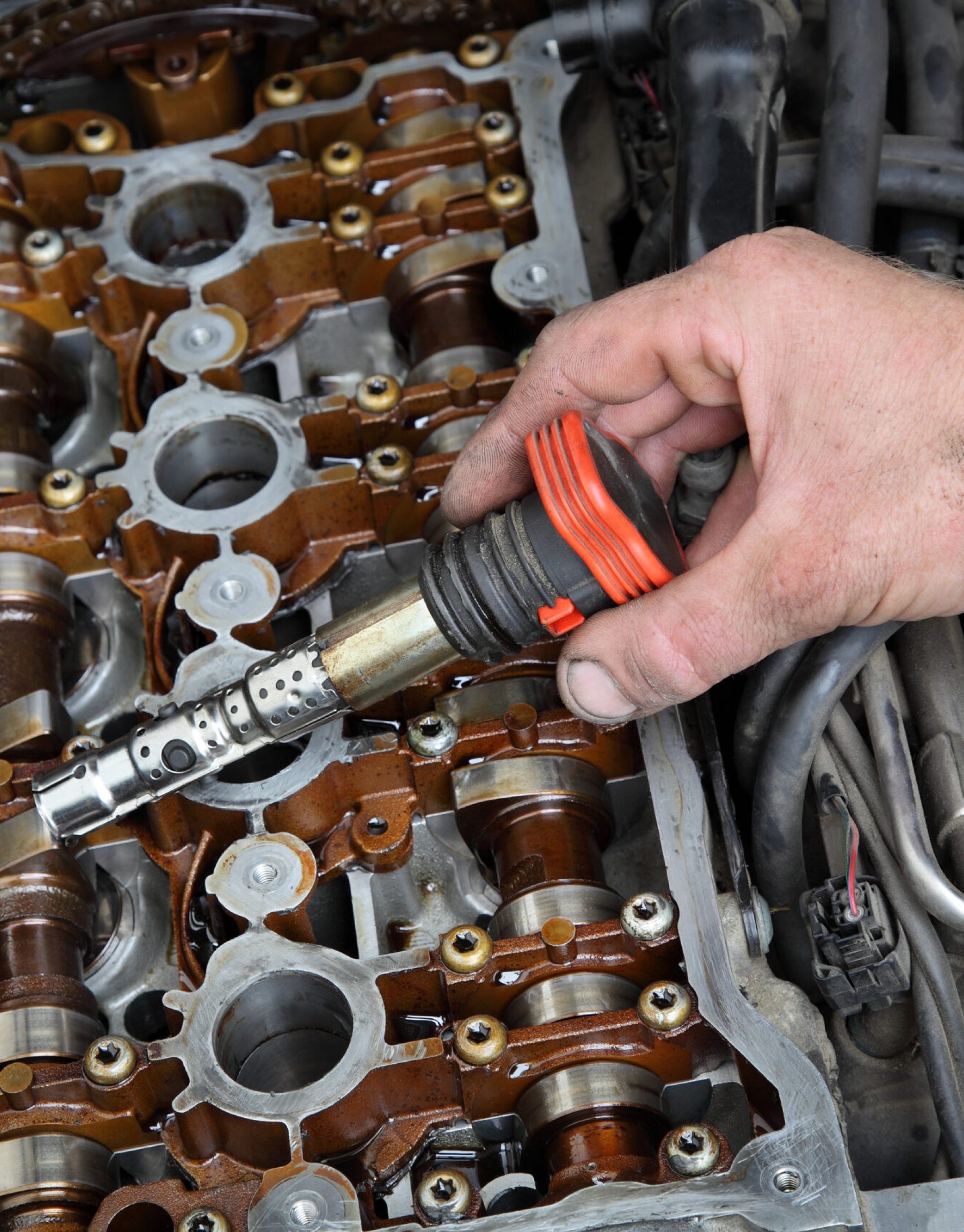 Car mechanic replacing ignition coil on gasoline engine